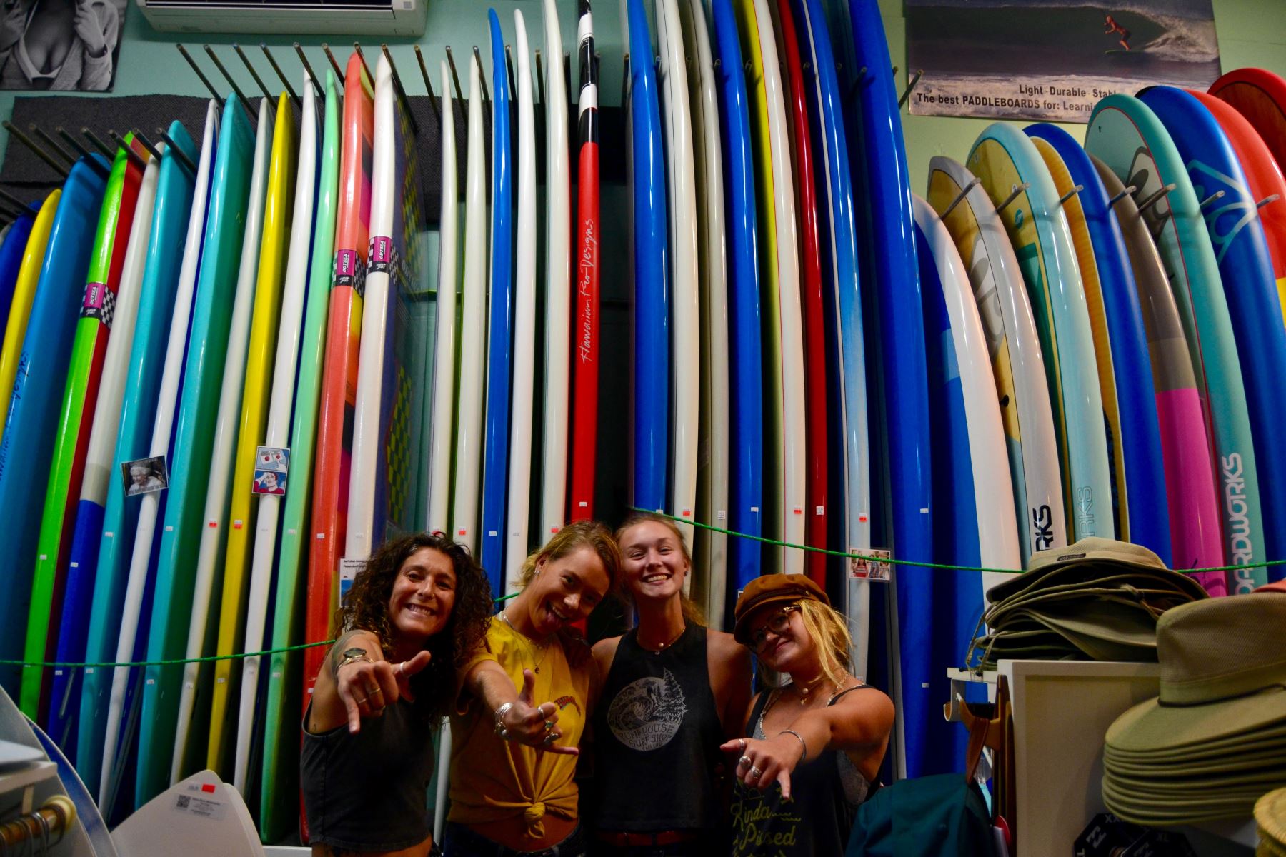 Pump House employees pose happily in front of surf boards  stop by for all your surf and skate gear on the Outer Cape